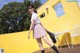 A woman in a school uniform is walking on a wooden deck.