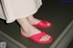 A woman wearing red sandals standing on a set of stairs.