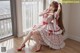 A woman in a red and white dress sitting on a chair.