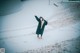 A woman wearing a face mask standing in the snow.