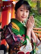 A woman in a colorful kimono is posing for a magazine.